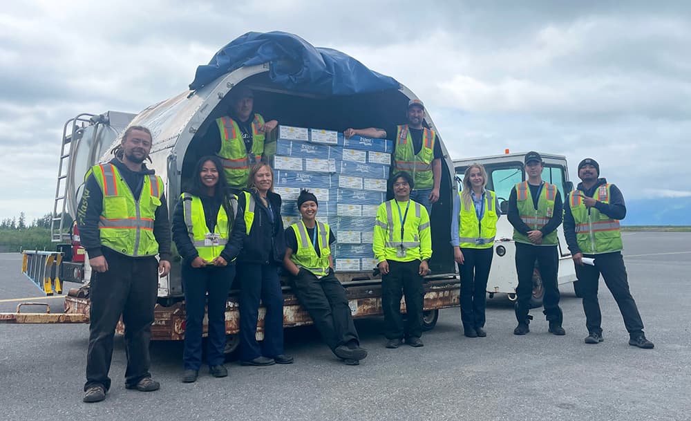 Alaska Air Cargo team with container filled with fish boxes, Cordova, Alaska.
