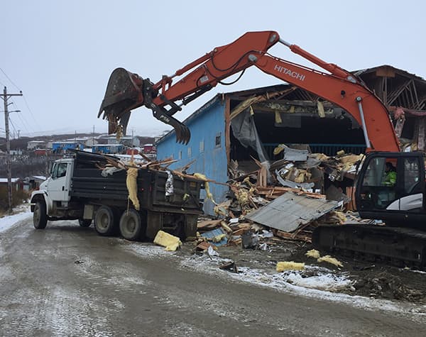 Heavy equipment demolishing a building